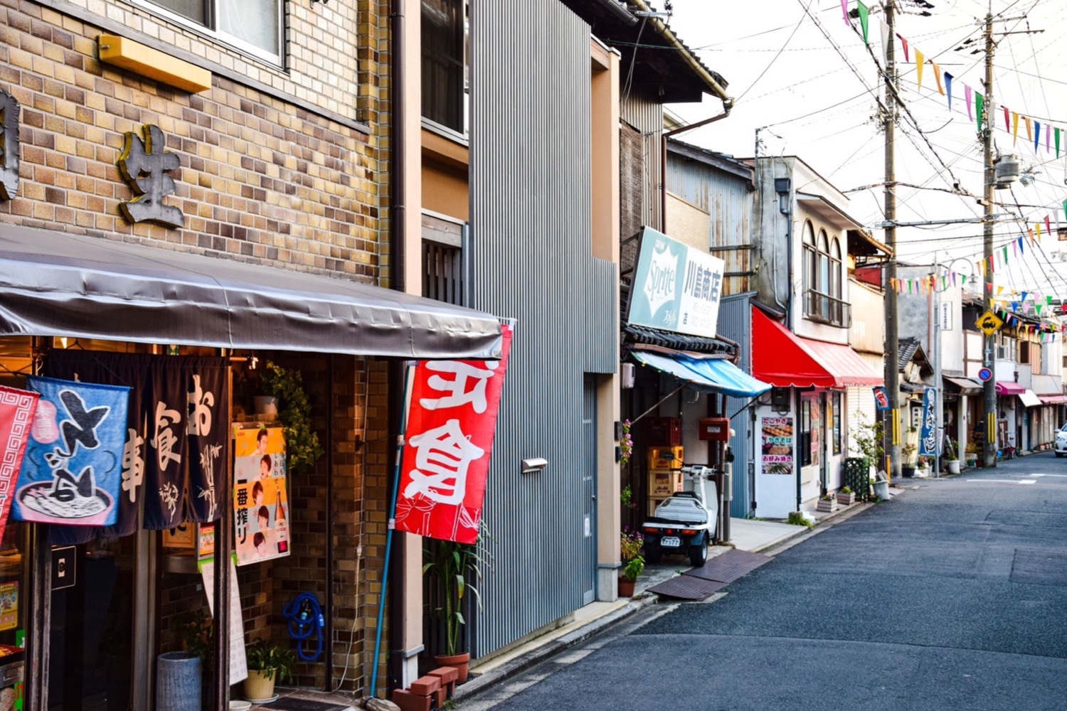 A narrow shopping street lined with storefronts and hanging signs.